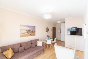a living room with a couch and a table at Apartament Bursztynowy in Rowy