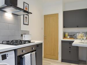 una cocina con estufa horno de arriba junto a una puerta en Westways, en Bridlington