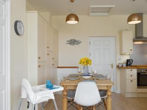 ウィットビーにあるFlowergate Houseのキッチン(木製テーブル、白い椅子付)