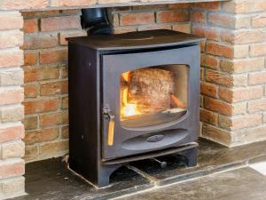 ein Holzofen mit einem Truthahn darin in der Unterkunft Cwmporthman Farm Cottage-Uk34701 in Blaenporth