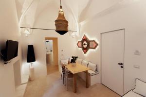 a dining room with a wooden table and chairs at Corte Manfredi in Alessano