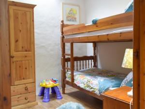 ein Kinderschlafzimmer mit Etagenbetten und einem Tisch in der Unterkunft Old Rectory Cottage - Dinas Country Club in Dinas + 9 Fotos