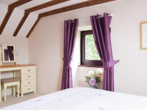Schlafzimmer mit lila Vorhängen und Fenster in der Unterkunft Hay Barn - Dinas Country Club in Dinas + 8 Fotos