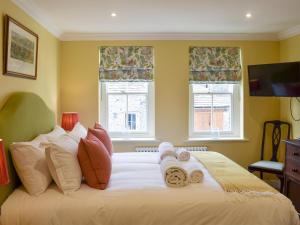 a bedroom with a white bed with towels on it at 2 The Reading Room Cottages - Uk31801 in Barningham