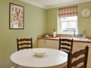 a kitchen with a table with a bowl on it at 2 The Reading Room Cottages - Uk31801 in Barningham