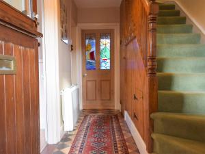 - un couloir avec une porte et des escaliers avec un tapis dans l'établissement Collingwood, à Marloes 7 autres photos