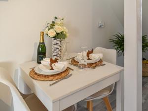 a table with two plates and a bottle of champagne at La Casita in Herne Bay