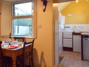 une cuisine avec une table et une fenêtre ainsi qu'une salle à manger dans l'établissement Collingwood, à Marloes