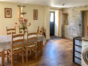 a kitchen and dining room with a table and chairs at Milkmaids Cottage-Uk31860 in Kniveton
