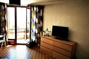 a living room with a tv on a dresser at Studio à 200 mètres la plage du Plan d'eau in Embrun