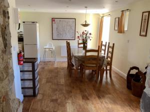 a kitchen and dining room with a table and chairs at Milkmaids Cottage-Uk31860 in Kniveton