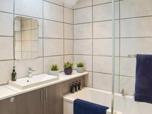 a bathroom with a sink and a mirror at The Cottage in Girvan +2 photos