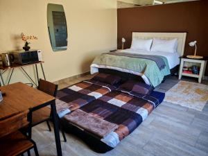 a bedroom with a large bed and a table at African Hoopoe Inn in Polokwane