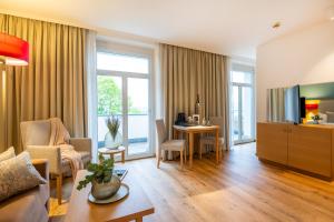 ein Wohnzimmer mit Couch und Fernseher in der Unterkunft Seehotel am Kaiserstrand in Lochau