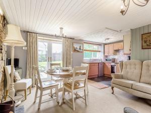 a kitchen and living room with a table and chairs at Holly Tree Cottage in Tain