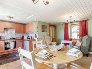 a kitchen and dining room with a wooden table at Holly Tree Cottage in Tain +21 photos