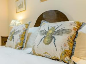 a bed with a pillow with a bee on it at Seaton Court - Uk31955 in Staithes