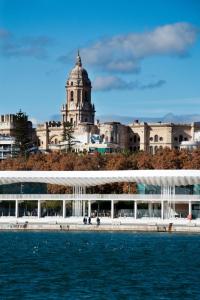 two pictures of a building and the water at Functional and Compact Studio in the Historic Center in Málaga