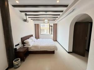 een slaapkamer met een bed en een groot raam bij Dawnscape snowmountain viewing Courtyard - Baisha old town in Lijiang +149 foto's