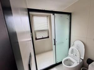 een kleine badkamer met een toilet en een raam bij Dawnscape snowmountain viewing Courtyard - Baisha old town in Lijiang