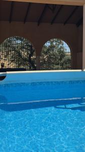 a blue swimming pool with two windows in a building at ALOJAMIENTO TURISTICO- AGROTURISMO Dehesa La Pared in Chillón