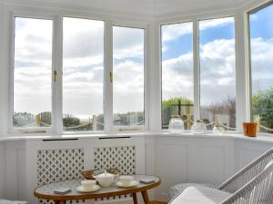 a room with windows and a table and chairs at Loanmhor in Kilmory