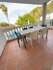 a wooden table and chairs on a balcony at Villa Apolo in Gandía