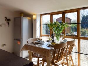 a kitchen with a table with chairs and a refrigerator at Twin Oaks in Crudgington