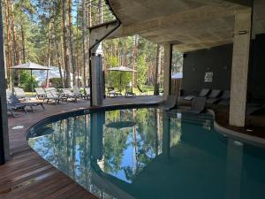 a swimming pool in a house with trees in the background at Sosnovel in Voropayev