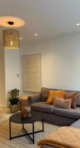 una sala de estar con un sofá y una mesa en Gezellig appartement Liva, en Blankenberge