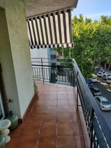 Un balcón con una sombrilla de rayas y una calle. en Beauty Big Apartment, en Salou