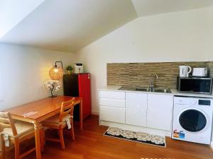 La cuisine est équipée d'une table, d'un évier et d'un four micro-ondes. dans l'établissement Love Cottage, à Glenwood