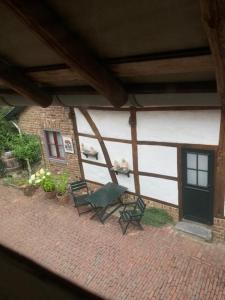 a patio with a green bench and a building at boerderij, voorhuis in Schimmert