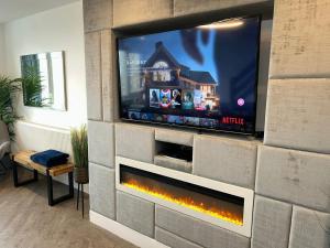a fireplace in a living room with a tv at Seaview House in Thornton