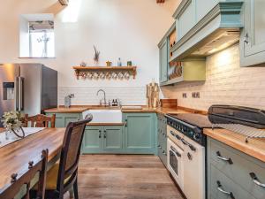 a kitchen with blue cabinets and a sink at Coach House in Rowston +17 photos