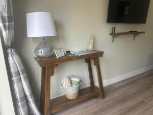 a wooden table with a lamp on top of it at Modern, newly built 2 bedroom bungalow with free parking, sleeps 6 in Hereford