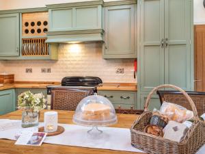 a kitchen with a table with a basket of food at Coach House in Rowston