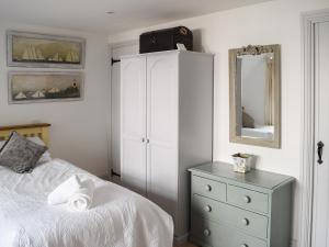 a bedroom with a bed and a dresser and a mirror at Shadycombe Lodge in Salcombe