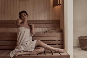 a woman is sitting in a sauna at The Chedi El Gouna in Hurghada