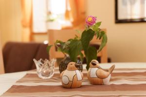deux oiseaux en peluche assis sur une table avec un vase dans l'établissement Wohnung Lusen, à Spiegelau