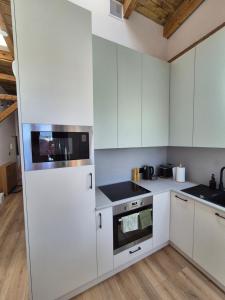 a kitchen with white appliances and wooden floors at Between the roofs of Jeżyce in Poznań +10 photos
