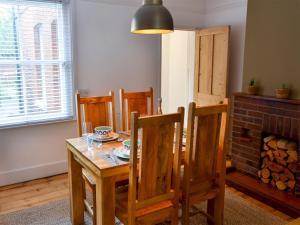 una sala da pranzo con tavolo e sedie in legno di Daisy Cottage a Sea Palling