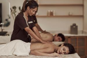 a woman getting a massage from a man on a bed at The Chedi El Gouna in Hurghada