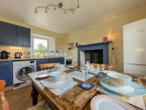 a kitchen with a wooden table with plates and wine glasses at Dalcharn in Bettyhill +18 photos