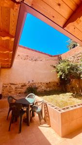 a patio with a table and chairs and a wall at La Bodega de la Valduerna 2 in Destriana
