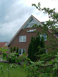 une maison en briques rouges avec des arbres devant elle dans l'établissement Schule 7, à Windeby