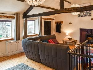 ein Wohnzimmer mit einer Couch und einem Kronleuchter in der Unterkunft Forge Cottage in Keswick