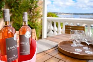 two bottles of wine sitting on a table with wine glasses at Jonaxel - Sur le port de Bandol in Bandol