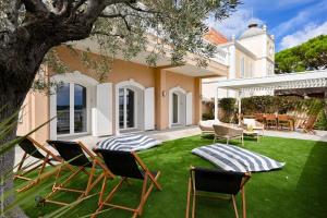 a yard with lawn chairs and a house at Jonaxel - Sur le port de Bandol in Bandol