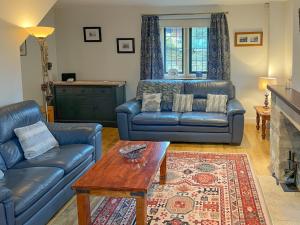 un salon avec un canapé et une table dans l'établissement Lavender Cottage, à Stretton on Fosse